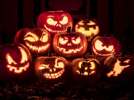 A group of glowing carved pumpkins with spooky faces, perfect for Halloween decoration.