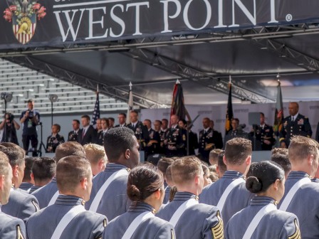A group of cadets stands at a ceremony under a 