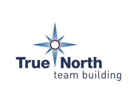 A logo showing a blue compass star rising from a circular center, with the words “True North” in bold and “team building” underneath.
